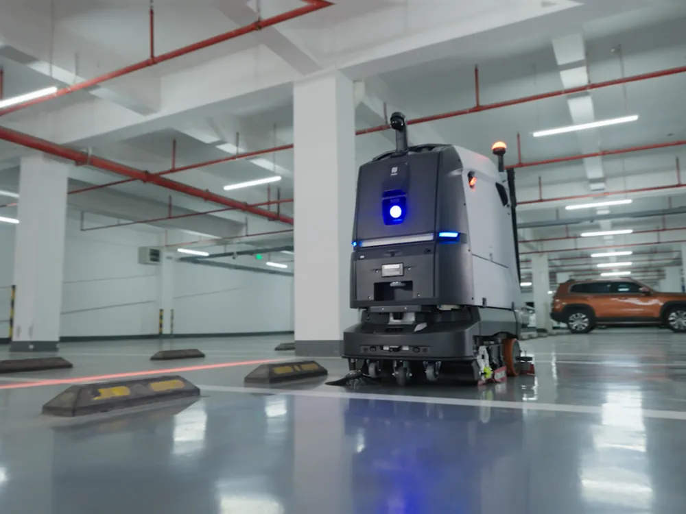 Robot per la pulizia dei pavimenti al lavoro in un'autorimessa